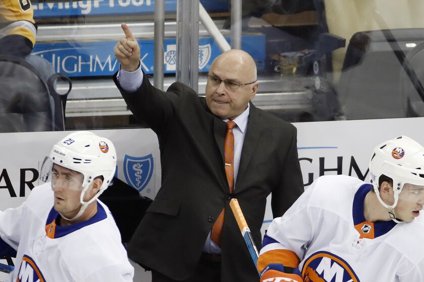 FILE - New York Islanders head coach Barry Trotz stands behind his bench during the first period of an NHL hockey game against the Pittsburgh Penguins in Pittsburgh, in this Tuesday, Nov. 19, 2019, file photo. The four coaches left in the NHL playoffs have connections to each other, but they all took different paths to get to this point. (AP Photo/Gene J. Puskar, File)
