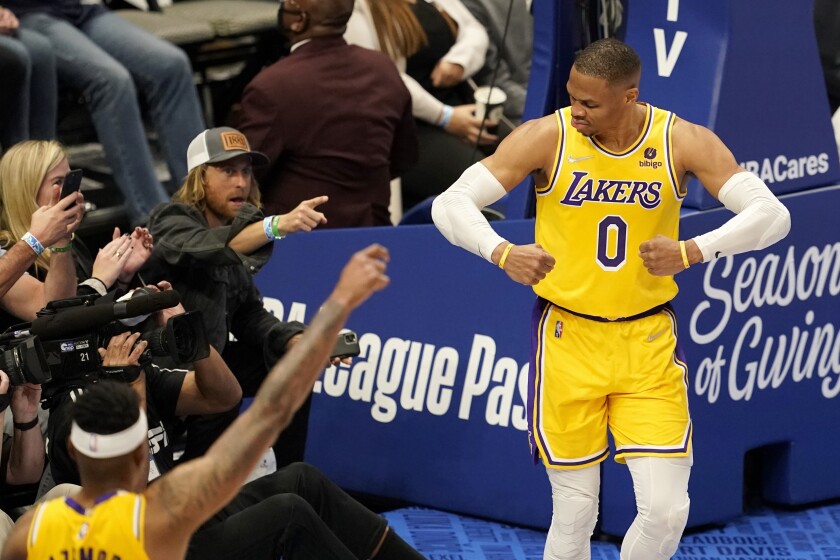 Los Angeles Lakers' Russell Westbrook (0) celebrates after sinking a basket as fans look on in the second half of an NBA basketball game in Dallas, Wednesday, Dec. 15, 2021. (AP Photo/Tony Gutierrez)