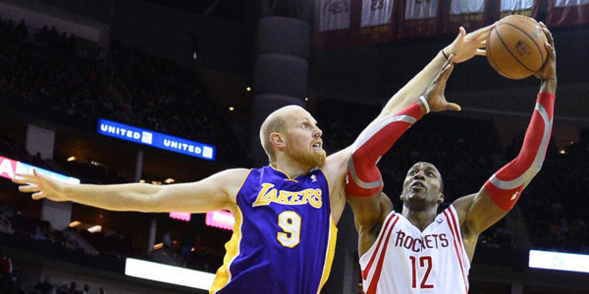 Lakers center Chris Kaman knocks the ball away from Houston Rockets forward Dwight Howard during a Lakers' loss.