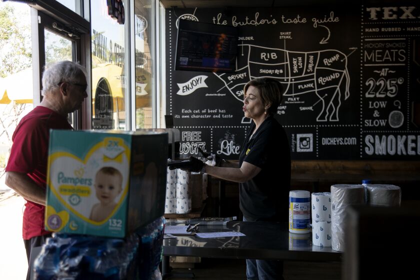 RANCHO MIRAGE, CALIFORNIA - APRIL 2, 2020: Restaurant owner Lisa Weaver takes a to-go order from a resident at Dickey's Barbecue Pit on April 3, 2020 in Rancho Mirage, California. She also is giving out free toilet paper and Pampers to those in need.(Gina Ferazzi/Los Angeles Times)
