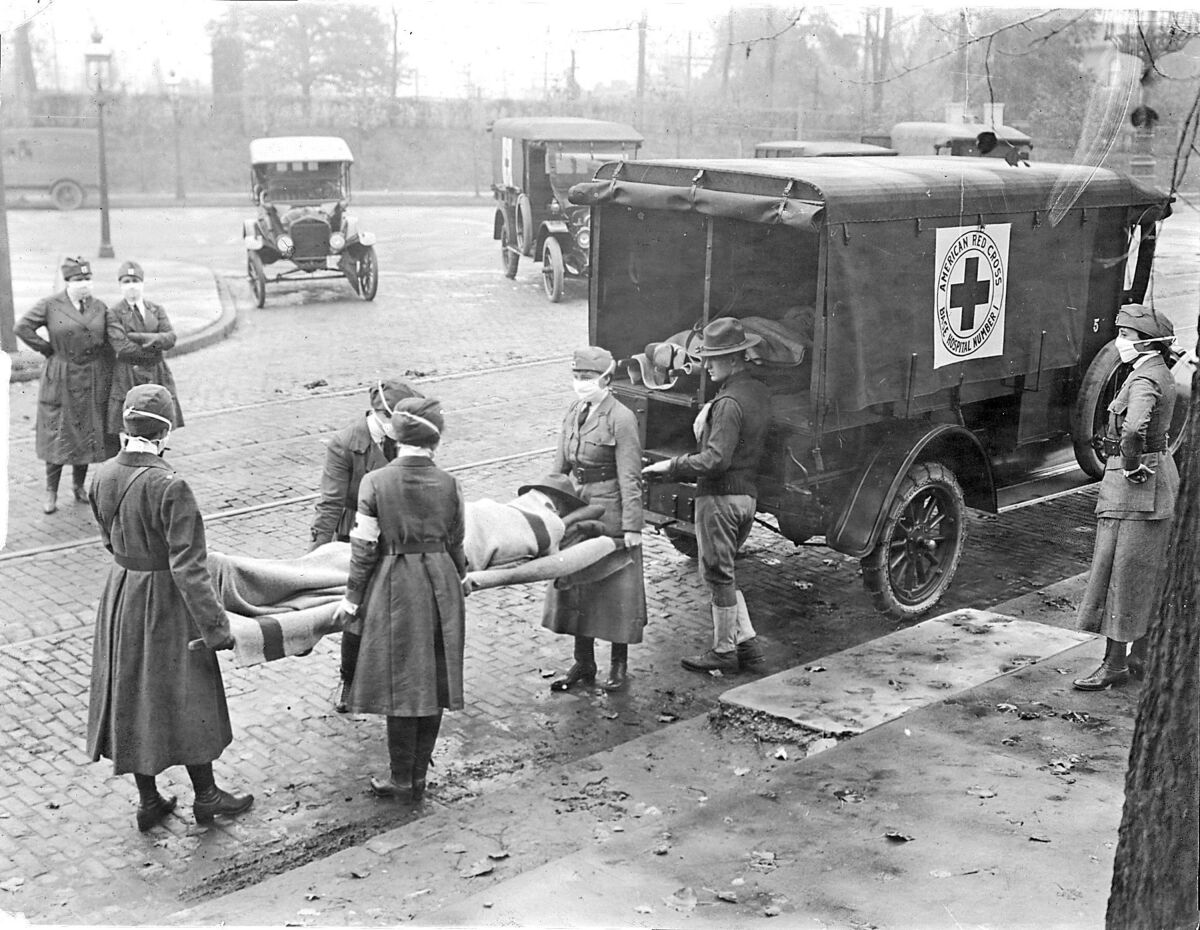 Red Cross members remove flu victims from a house in 1918