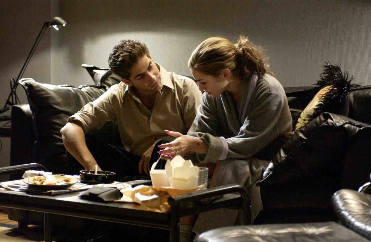 Michael Imperioli as Christopher and Drea de Matteo as Adriana sit on a couch in "The Sopranos."