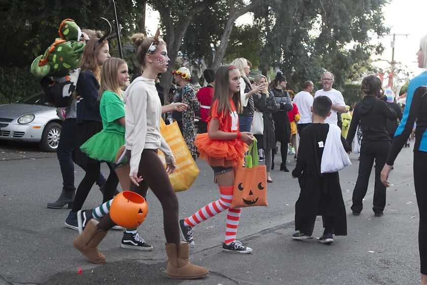 A group of trick-or-treaters joins the crowd during the Oak Street Halloween Block Party in Laguna Beach on Tuesday evening.