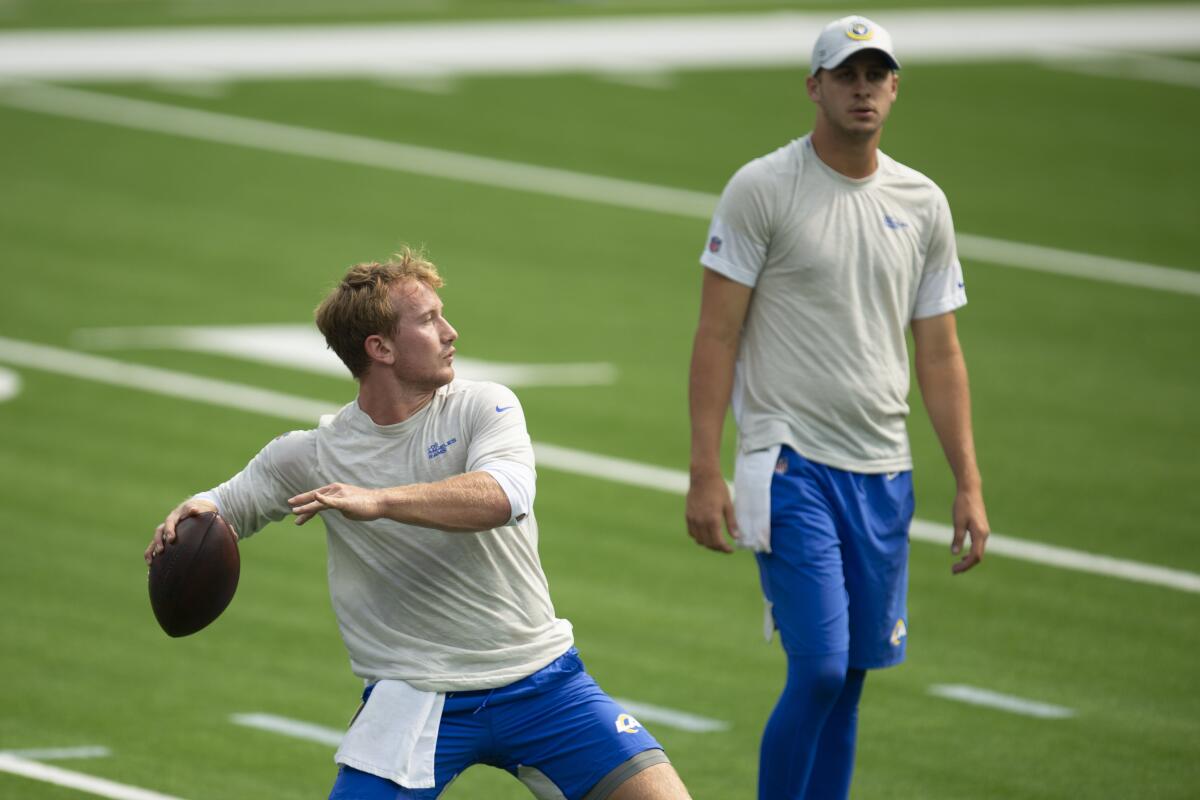 Rams quarterback John Wolford throws in front of starting quarterback Jared Goff.