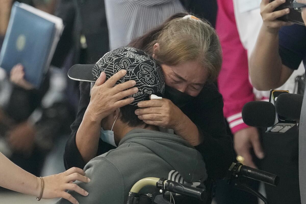 Una mujer abraza a un trabajador tailandés que fue evacuado de Israel debido a la guerra,