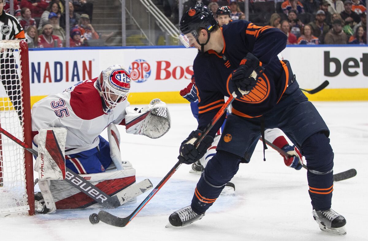 Montreal Canadiens' goalie Sam Montembeault (35) makes the save against Edmonton Oilers' Zach Hyman (18) during second-period NHL hockey game action in Edmonton, Alberta, Saturday, March 5, 2022. (Jason Franson/The Canadian Press via AP)