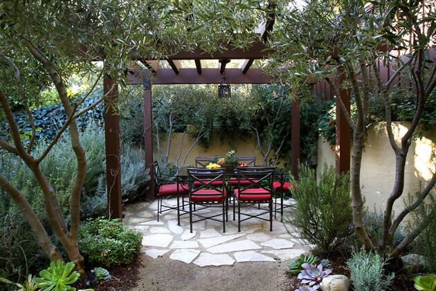 One of the homeowner's father built the wood dining pergola, where the only outdoor lantern original to the house was rewired and given pride of place. Brown Jordan furniture with cushions covered in fade-resistant Sunbrella fabric complete the space.