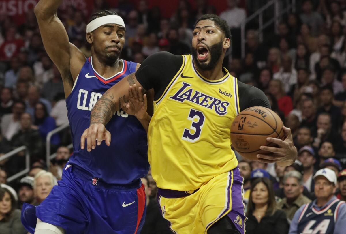 Lakers forward Anthony Davis (3) drives against Clippers forward Maurice Harless during the season opener