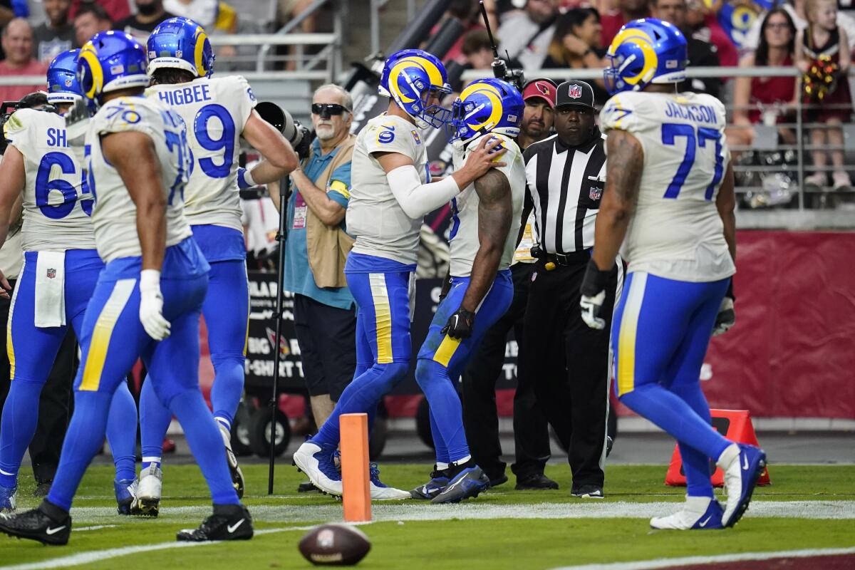 Rams quarterback Matthew Stafford (9) congratulates Cam Akers after his touchdown run against the Arizona Cardinals.