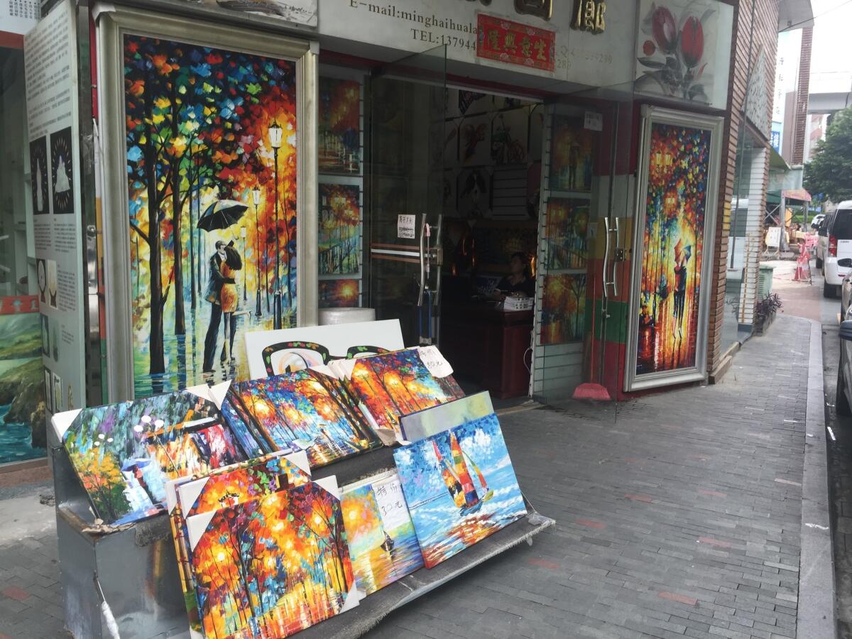 Paintings are displayed on a street in China's Dafen Oil Painting Village.