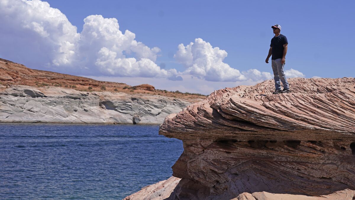 Bill Schneider stands near Antelope Point's public launch ramp off Lake Powell, which closed to houseboats as early as October of 2020 Saturday, July 31, 2021, near Page, Arizona. This summer, the water levels hit a historic low amid a climate change-fueled megadrought engulfing the U.S. West. (AP Photo/Rick Bowmer)