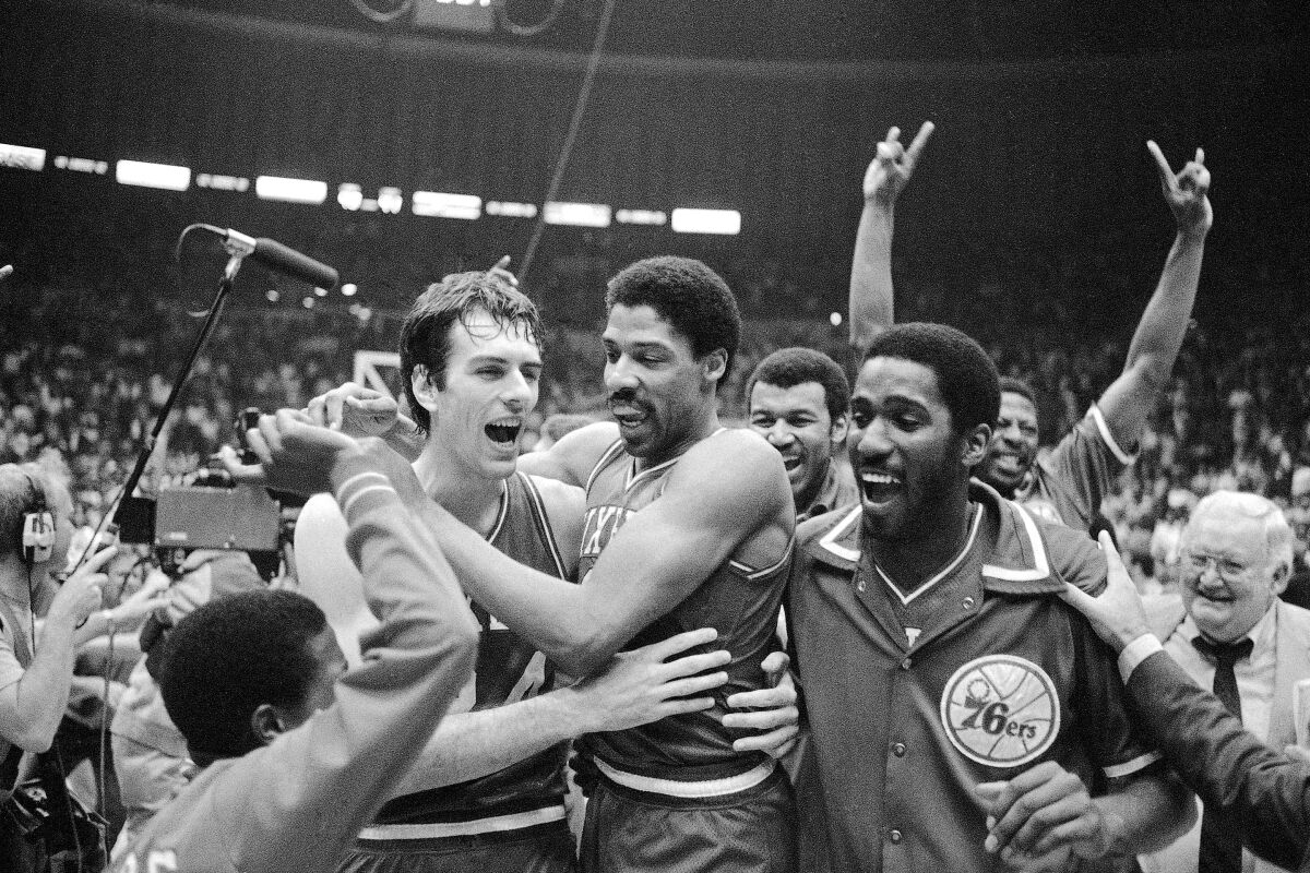 FILE - Philadelphia 76ers Bobby Jones, left, embraces Julius Erving after the 76ers defeated the Los Angeles Lakers in four straight games to win the NBA Championship, May 31, 1983. (AP Photo, File)