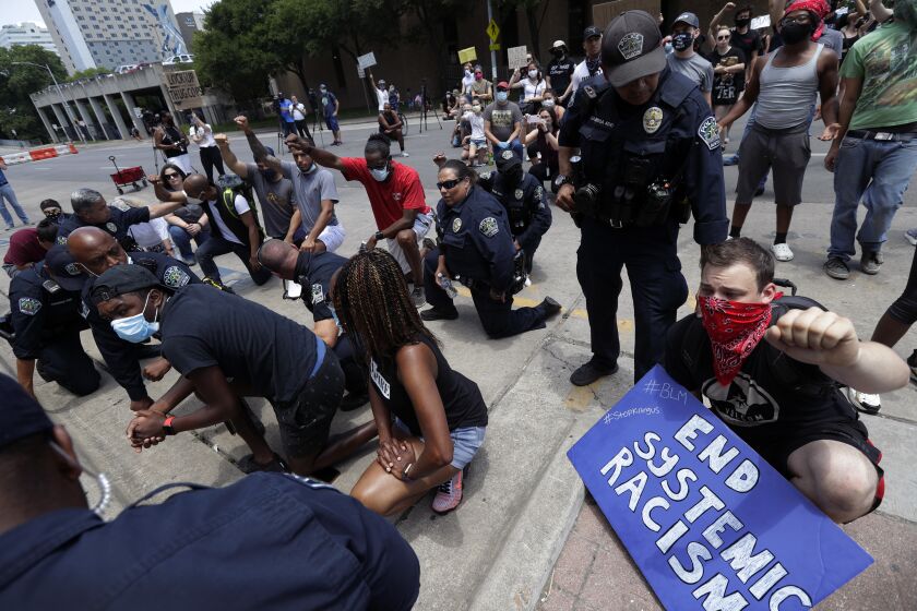 Members of the Austin Police Department kneel with demonstrators who gathered in Austin, Texas, Saturday, June 6, 2020, to protest the death of George Floyd, a black man who was in police custody in Minneapolis. Floyd died after being restrained by Minneapolis police officers on Memorial Day. (AP Photo/Eric Gay)