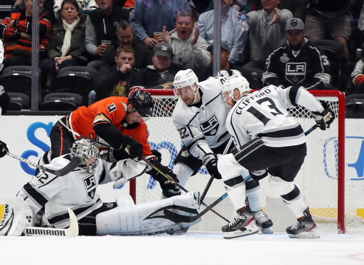 Kings goaltender Jonathan Quick and teammates Trevor Lewis and Kyle Clifford try to stop Ducks defenseman Cam Fowler from scoring.