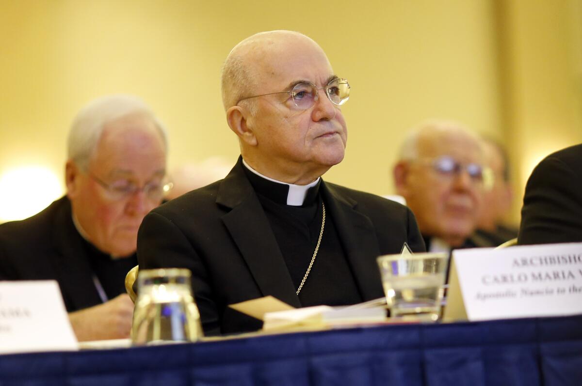 A man sits and listens during a meeting of Catholic Bishops.