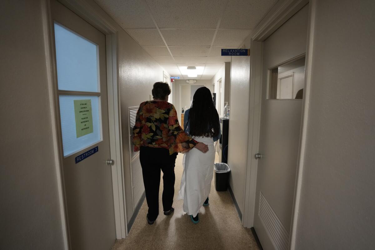 Two women walk down a hall