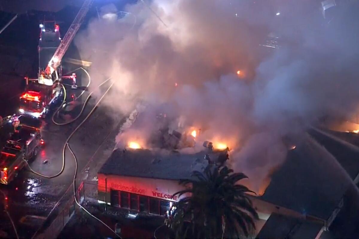 An aerial view of fire engines spraying water onto a fire.