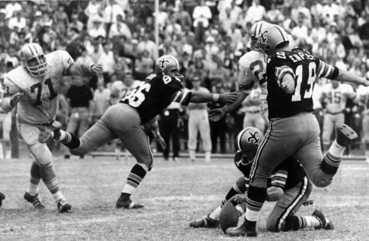 Tom Dempsey kicks a 63-yard field goal in New Orleans on Nov. 8, 1970. The record-setting kick gave the Saints an upset 19-17 win over the Lions. Joe Scarpati is the holder. Detroit’s Alex Karras (71) and Saints’ Bill Cody (66) are also pictured.