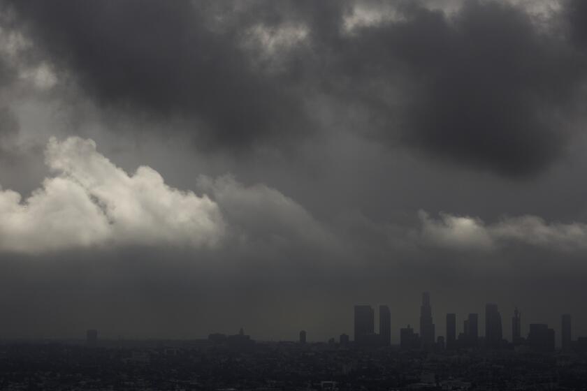 Low clouds drift over the Los Angeles Basin and downtown as light rain and cooler temperatures prevail on Oct. 18.