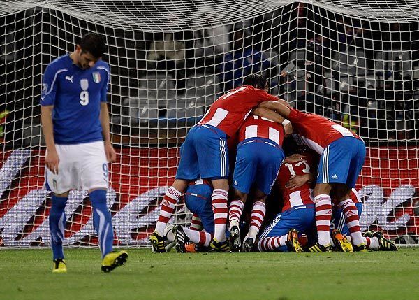 Italy's Vincenzo Iaquinta, left, walks away in dejection as Paraguay's players celebrate after their teammate Antolin Alcaraz scored during a World Cup Group F match in Cape Town, South Africa, on Monday.