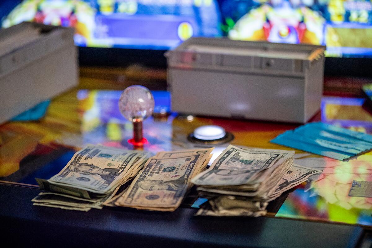 Piles of cash are lined up near gambling machines.