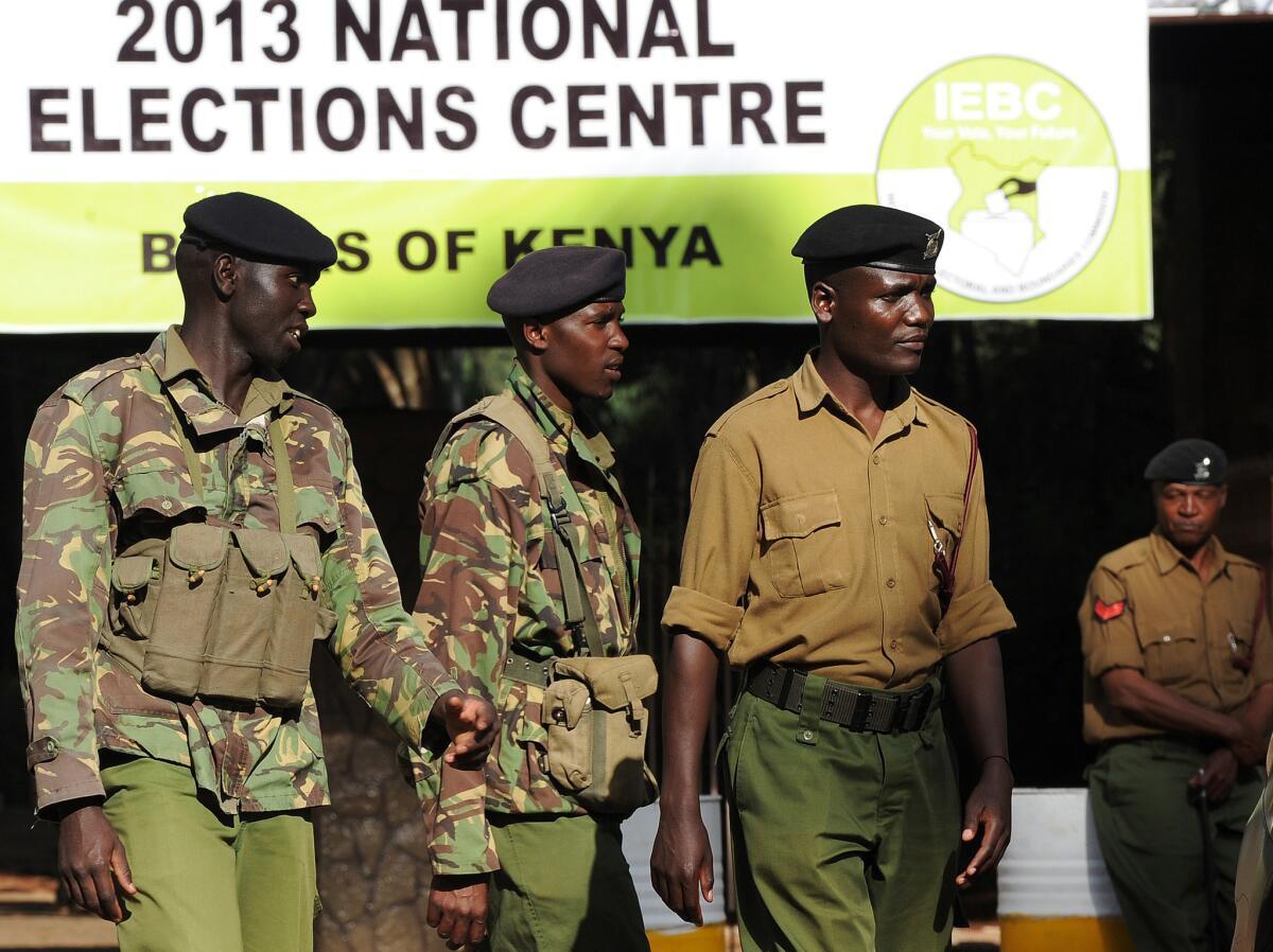 Kenyan police officers stand guard at the entrance to a Nairobi polling station where election commissioners were at work.