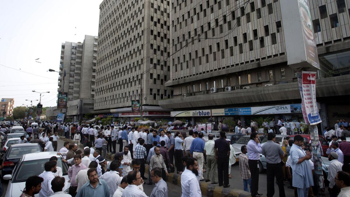 People evacuate buildings and gather on a road after an earthquake in eastern Iran on Tuesday was felt in Karachi, Pakistan. The quake was estimated to have a magnitude of at least 7.5, authorities said, but there were conflicting reports regarding any casualties.