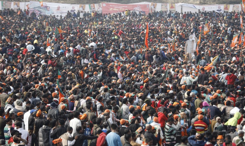 FILE - A crowd of supporters gather to listen to Indian Prime Minister Narendra Modi as he lays the foundation stone of Major Dhyan Chand Sports University in Meerut, Uttar Pradesh state on Jan. 2, 2022. Coronavirus cases fueled by the highly transmissible omicron variant have rocketed through India and the country is scrambling to ward off its impact by swiftly introducing a string of restrictions that the population thought were history. But India’s political leaders, including Modi, have largely flouted some of these guidelines and traversed cities in a massive campaign trail ahead of crucial state polls, addressing packed rallies of tens of thousands of people without masks. (AP Photo/Rajesh Kumar Singh, File)