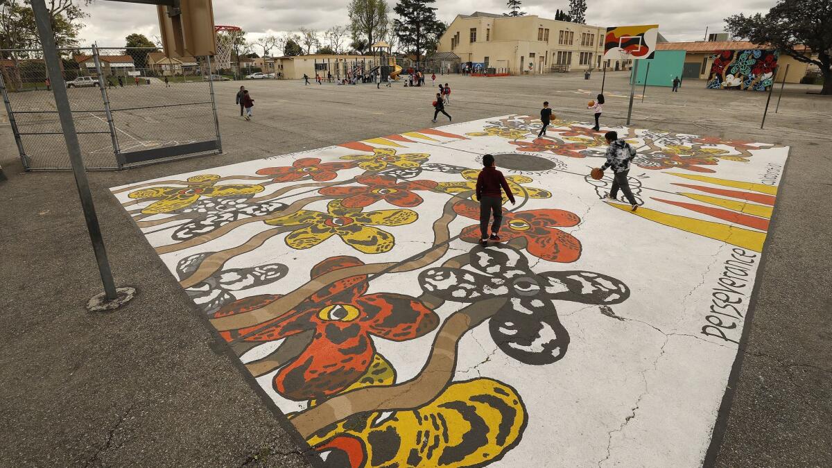 Third-graders play during recess on the basketball court at 59th Street Elementary School, decorated with artwork commissioned by Nipsey Hussle.