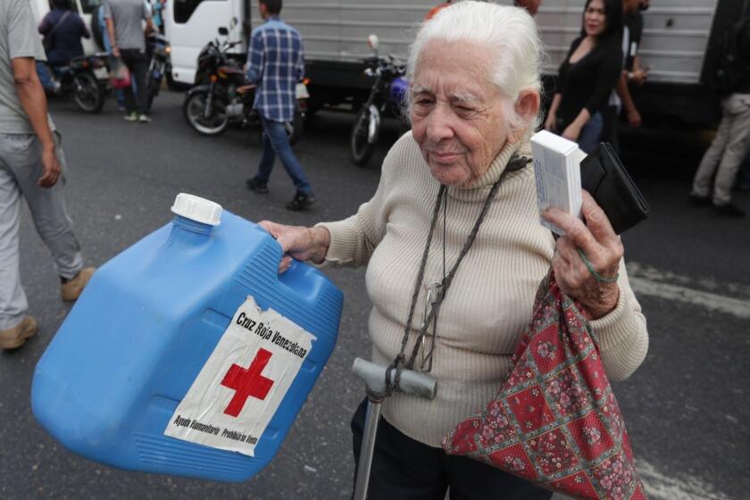 Mandatory Credit: Photo by Rayner Pena/EPA-EFE/REX (10208672e) A woman receives a box of the first shipment of humanitarian aid from the Red Cross, in Caracas, Venezuela, 16 April 2019. A plane with humanitarian aid arrived in Venezuela on 16 April through the International Airport of Maiquet?a, near Caracas, and was received by a group of the Red Cross, according to several opposition deputies. The shipment came after last week Venezuelan President Nicolas Maduro announced an agreement with the Red Cross for the entry of aid to Venezuela. Members of the Red Cross distribute humanitarian aid in Caracas, Venezuela - 16 Apr 2019 ** Usable by LA, CT and MoD ONLY **