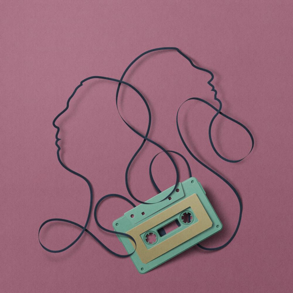A casette tape and outlines of two faces.