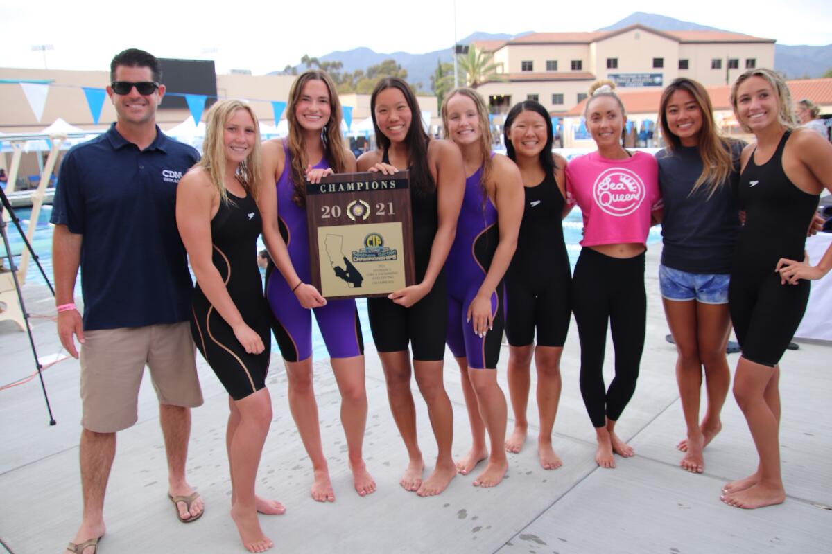 The Corona del Mar High School girls' swim team celebrates with the CIF Southern Section Division 2 title plaque. 