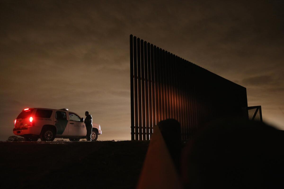 Agentes de la Patrulla Fronteriza cerca de una sección de la valla fronteriza México-Estados Unidos en La Joya, Texas.
