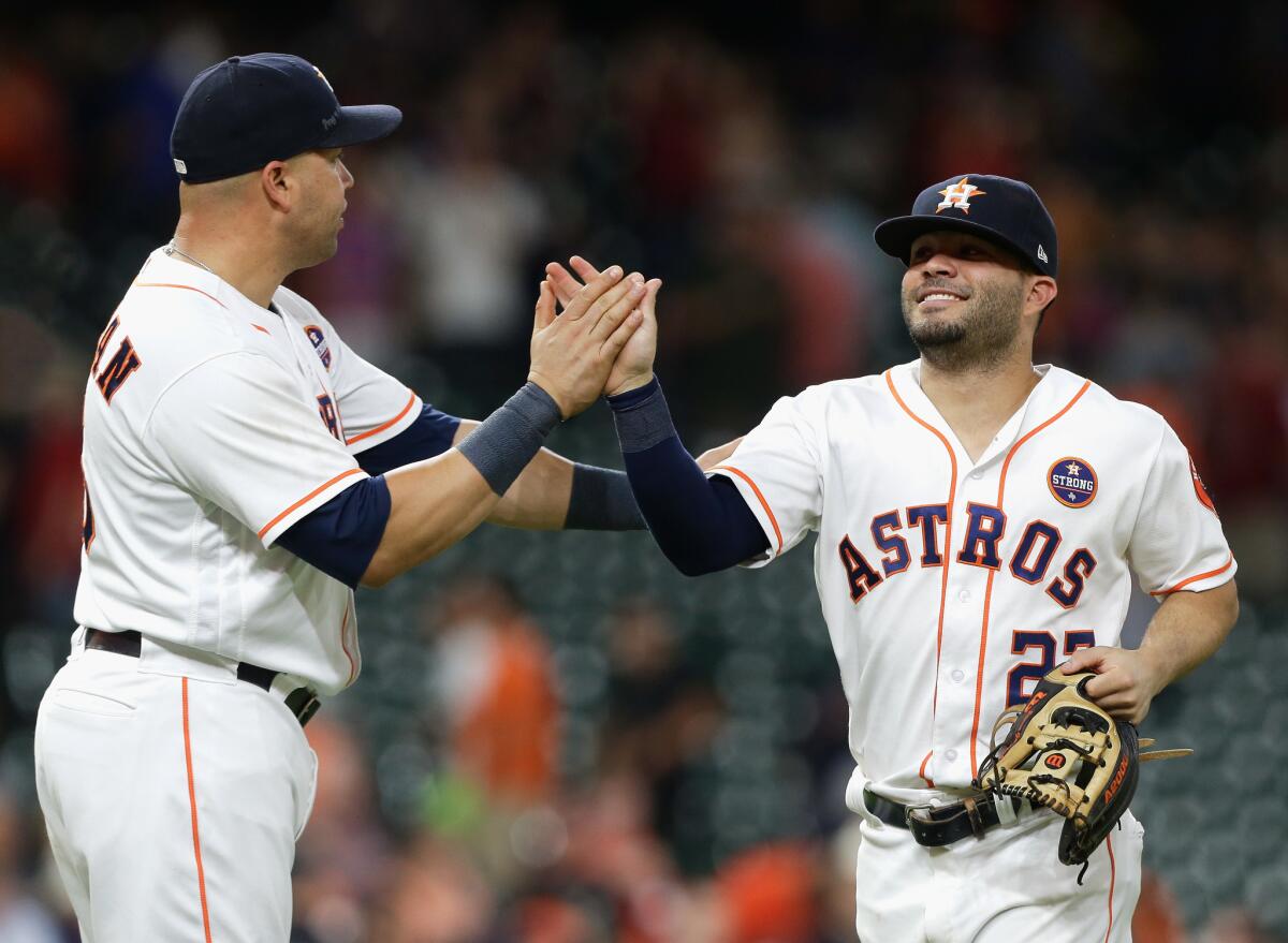 Astros second baseman Jose Altuve gets a high-five from veteran teammate Carlos Beltran after finishing off another win during the regular season.