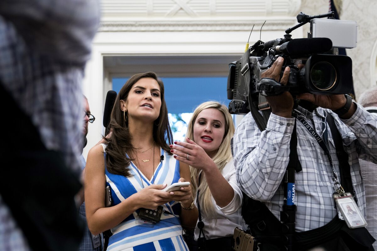 Two people in a crowd of media reporters
