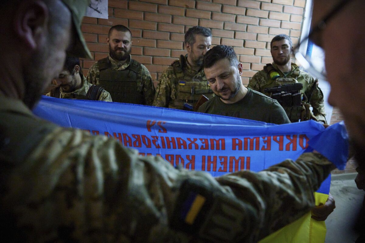 Ukrainian President Volodymyr Zelensky inspecting a military flag