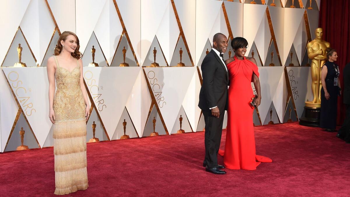 Emma Stone, left, Julius Tennon and Academy Award winner Viola Davis arrive at the Oscars on Sunday at the Dolby Theatre.