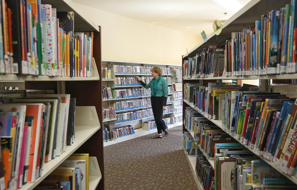 Julie Davey shows the aisles of the children's corner of the Laguna Niguel Library.