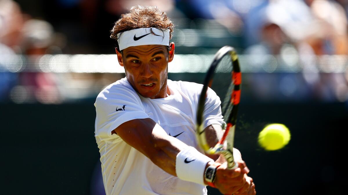Rafal Nadal hits a return during his first-round match against Thomaz Bellucci at Wimbledon on June 30, 2015.