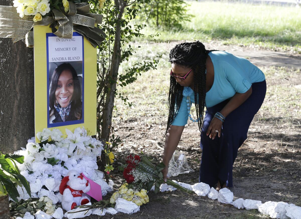 Jeanette Williams places a bouquet of roses at a memorial for Sandra Bland near Prairie View, Texas, on July 21. A newly released dash-cam video documents how a routine traffic stop escalated into a confrontation between a Texas state trooper and Bland, which led to her arrest. Bland was found hanging in her jail cell three days later.