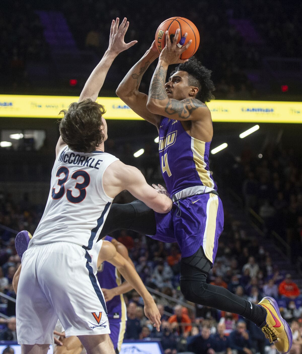 James Madison guard Vado Morse (4) goes up for a shot over Virginia guard Carson McCorkle (33) during the second half of an NCAA college basketball game, Tuesday, Dec. 7, 2021, in Harrisonburg, Va. (Daniel Lin/Daily News-Record via AP)