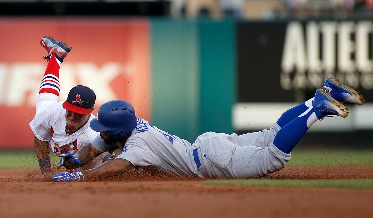 Howie Kendrick of the Dodgers avoids the tag of Cardinals second baseman Kolten Wong on a first-inning double.