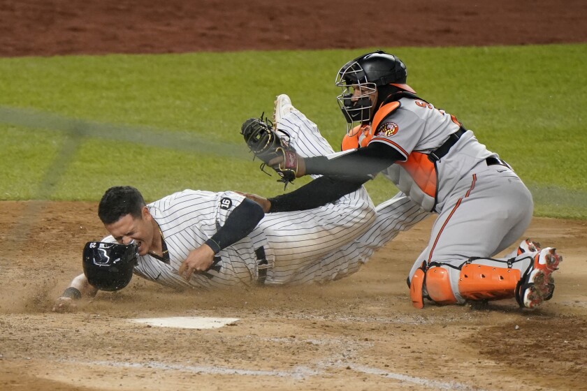 New York Yankees' Gio Urshela reacts after being tagged on the face by Baltimore Orioles catcher Pedro Severino (28) on a double play during the 11th inning of a baseball game Wednesday, April 7, 2021, at Yankee Stadium in New York. (AP Photo/Kathy Willens)