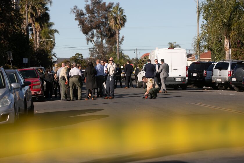 San Diego, CA - December 08: Officials with San Diego Police and San Diego Sheriff's Department arrive at the scene of an officer-involved shooting in the 4000 block of 42nd Street in San Diego, CA on Thursday, Dec. 8, 2022. (Adriana Heldiz / The San Diego Union-Tribune)