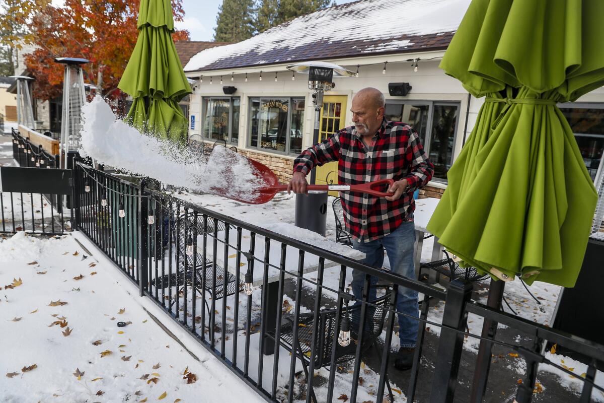 A man clears snow from a patio.