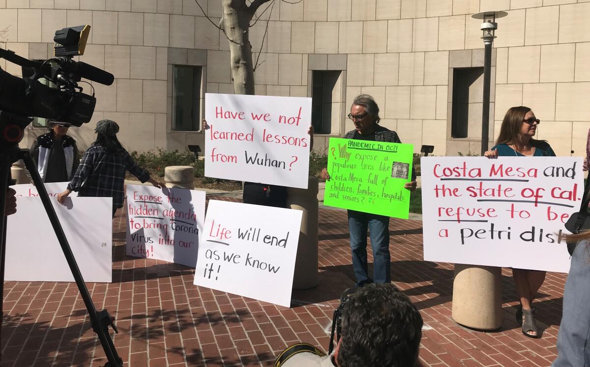 Protesters gather Monday outside the federal courthouse in Santa Ana before a hearing on the possibility of sending people infected with coronavirus to Costa Mesa.