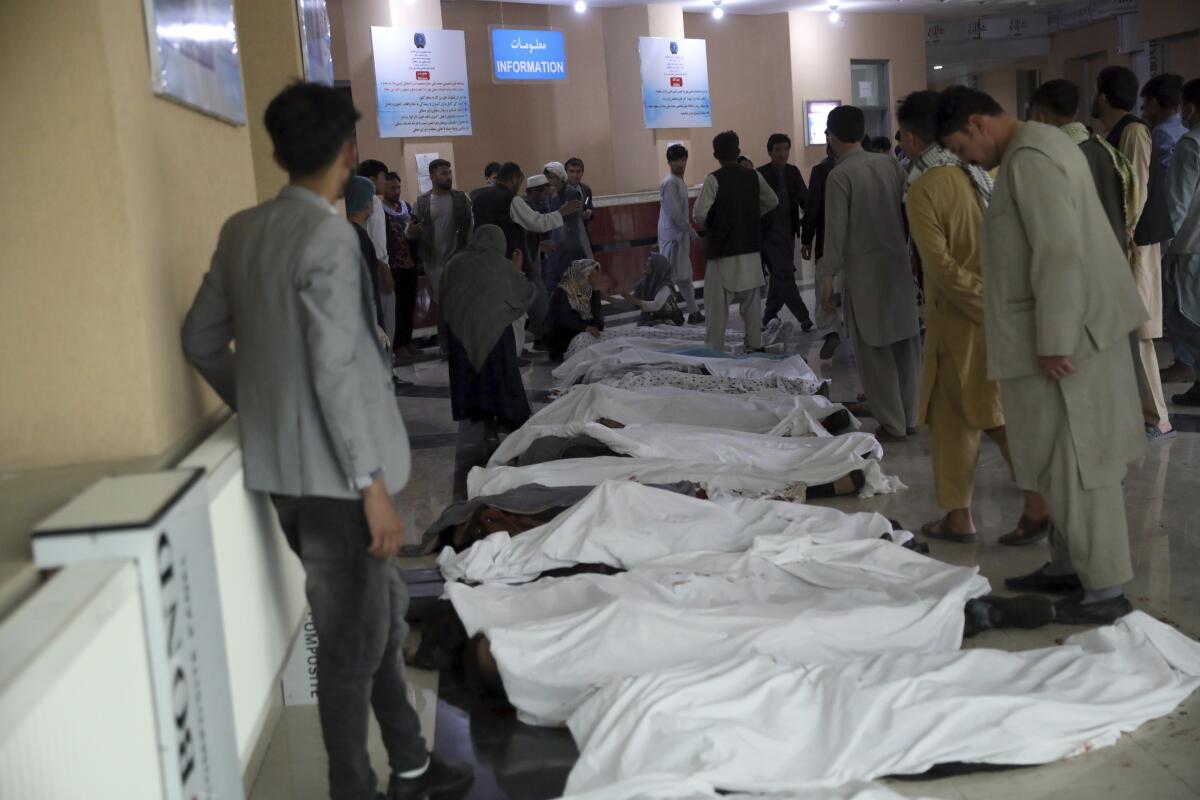 Hombres afganos intentan identificar los cuerpos 