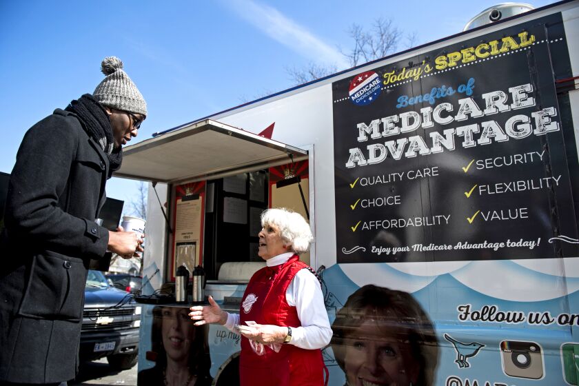 UNITED STATES - MARCH 9: Carol Berman, of West Palm Beach, Fla., speaks with pedestrians about the need for policymakers to protect Medicare Advantage benefits during the Coalition for Medicare Choices' Medicare Advantage Food Truck stop on North Capitol Street in Washington on Monday, March 9, 2015. Seniors shared cookies, coffee and personal stories about Medicare Advantage while standing outside of the food truck. (Photo By Bill Clark/CQ Roll Call)