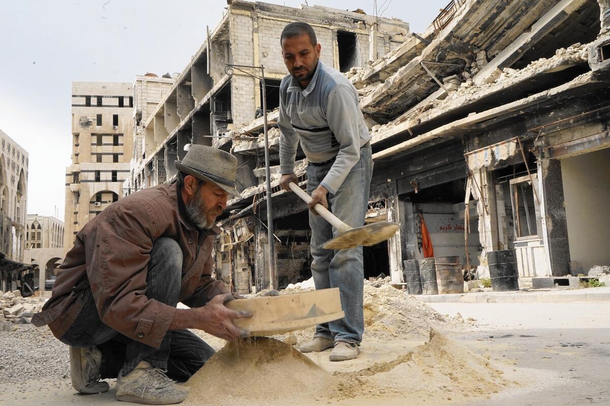 Workers rebuild a shop near the old souk in Homs, Syria. The city’s last rebel stronghold has finally begun reverting back to government control under a U.N.-brokered agreement.