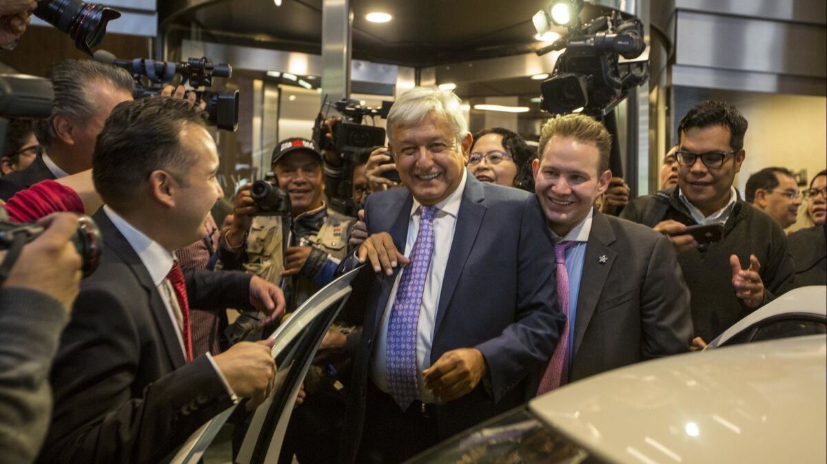 Mexico's President-elect Andres Manuel Lopez Obrador is surrounded by the press as he leaves a Mexico City hotel where he gave a news conference Monday.